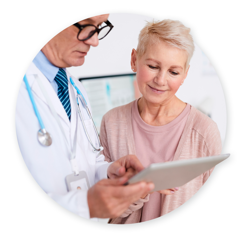 Doctor showing elderly female patient information on tablet