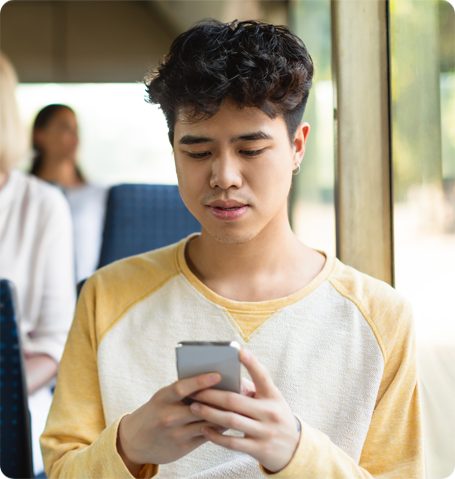 Teenager on bus looking at phone