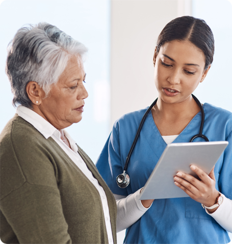 Doctor and elderly patient reviewing medical chart on ipad