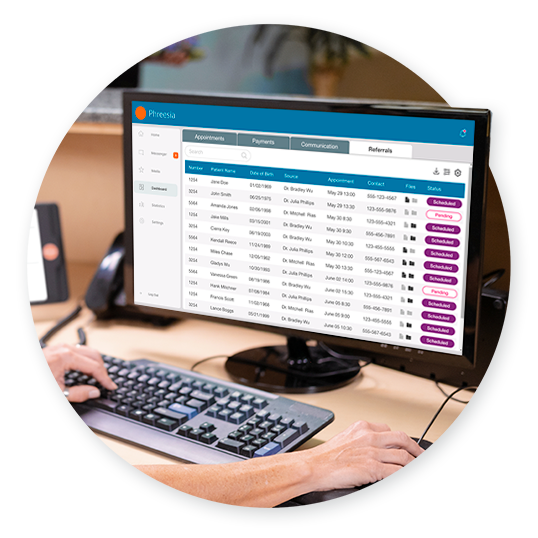 Front desk worker using Phreesia's referral management software on desktop computer